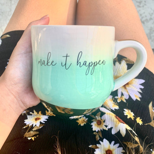 Woman holding a mint green ombre mug that says Make It Happen